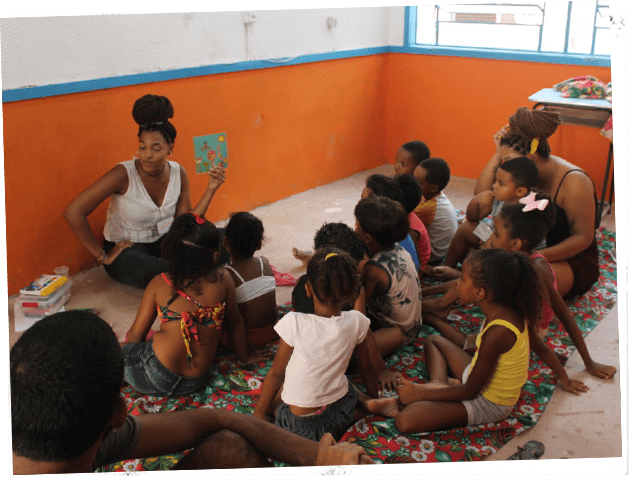 Professora fazendo atividade com crianças durante a Colônia de Férias